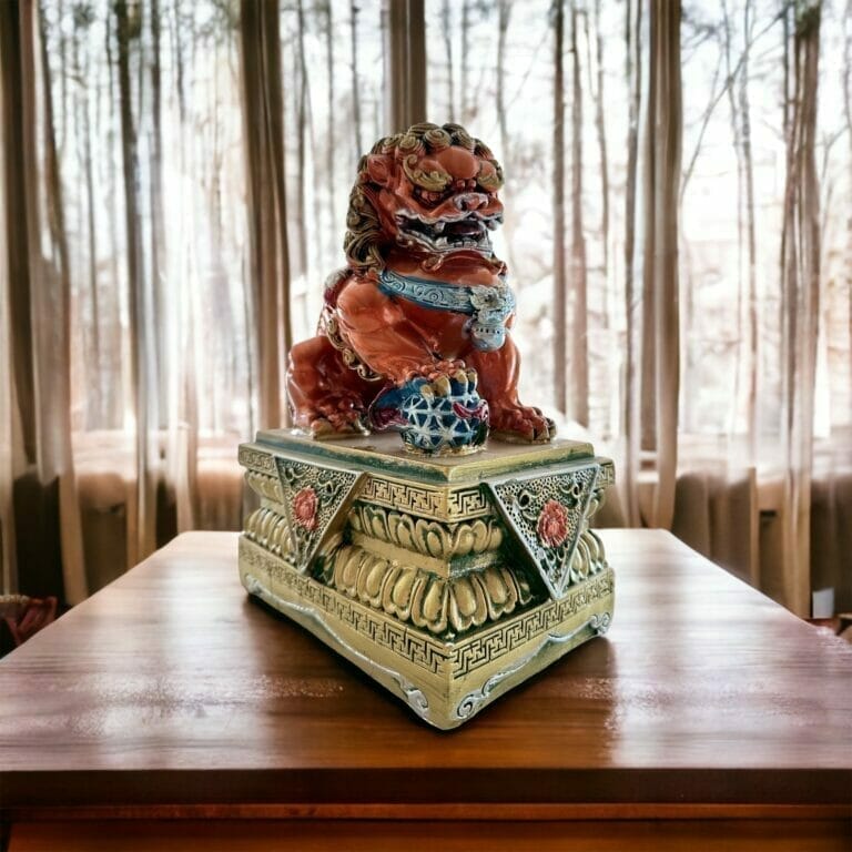 Eine chinesische Löwenstatue sitzt auf einem Tisch vor einem Fenster.