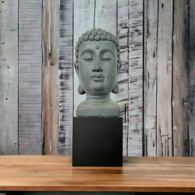 Eine Statue eines Buddha-Kopfes auf einem Holztisch.
