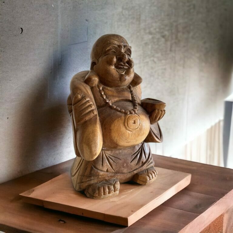 Eine hölzerne Statue eines Buddha, der auf einem Tisch sitzt.